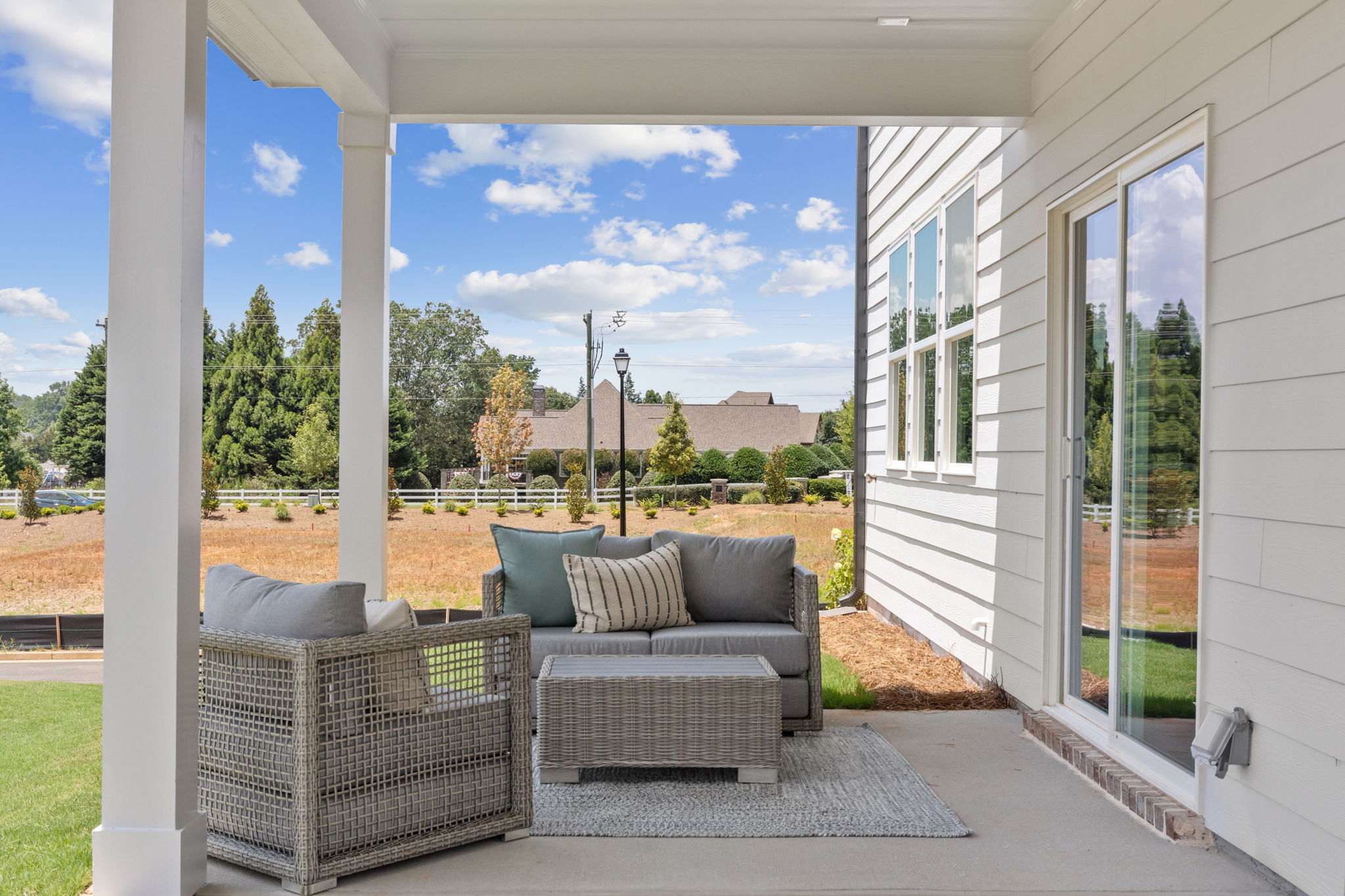 A white house with a patio and a white wall and a white building.