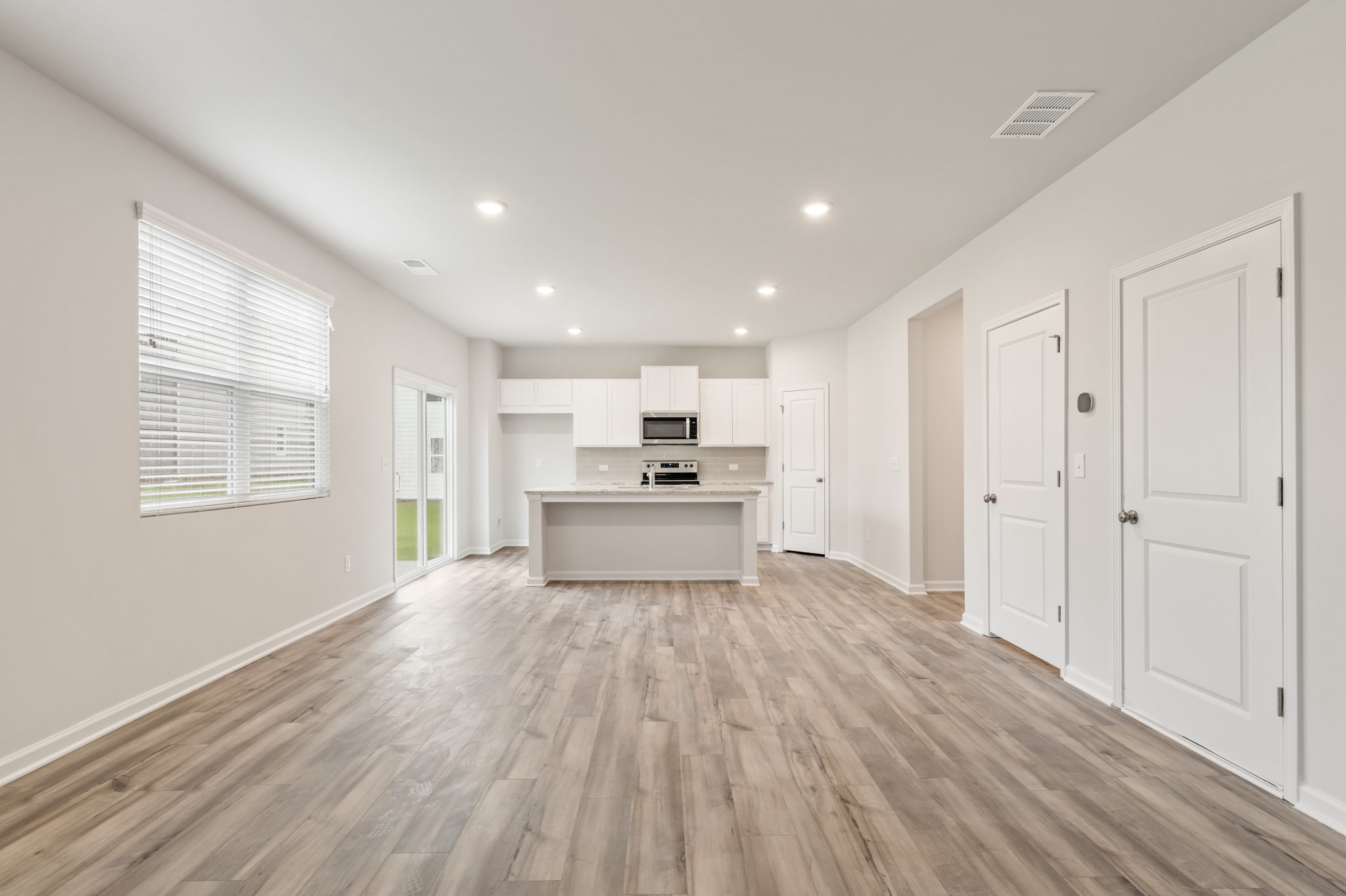 A large empty room with white cabinets.