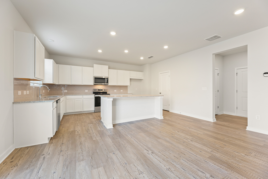 A kitchen with white cabinets.
