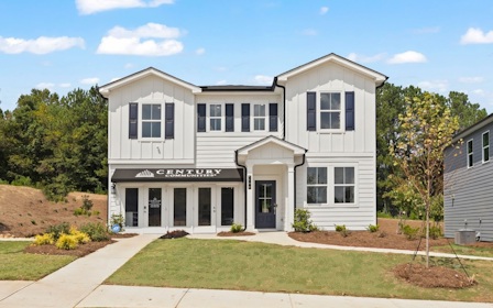 A white building with a lawn in front of it.