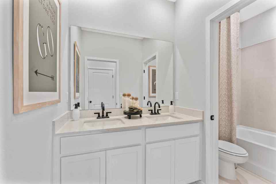 Silverbell II Model Home Guest Bath with Dual Sinks and Shower with Tub at Camden Woods in Kingsland, GA