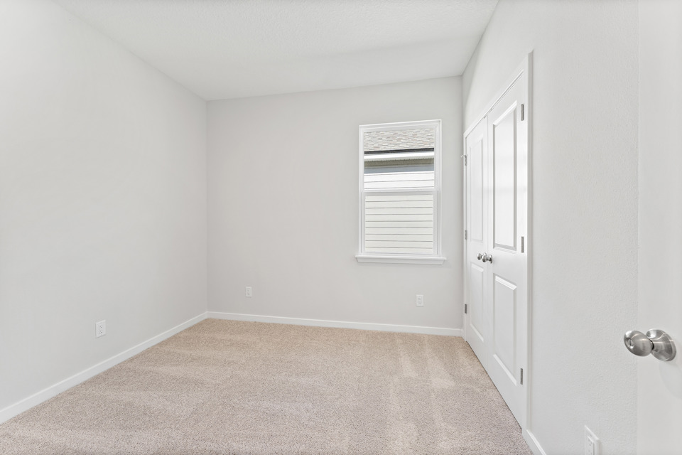 Lot 19 Cedar II Guest Bedroom with Window and Double Closet Doors at Camden Woods in Kingsland, GA