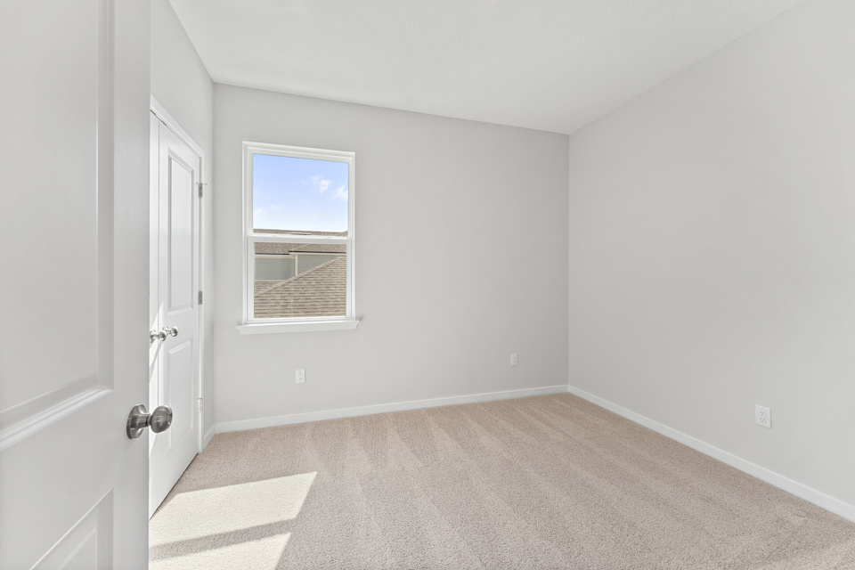 Lot 20 Ponderosa II Guest Bedroom with Window and Double Closet Doors at Camden Woods in Kingsland, GA