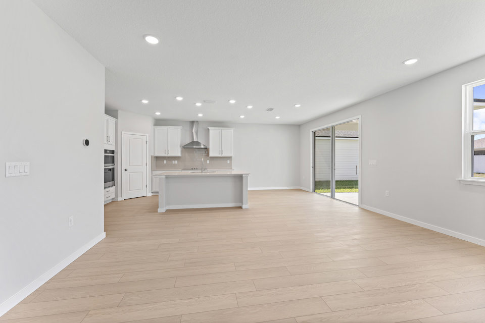 Lot 20 Ponderosa II Living Area Looking at Kitchen and Sliding Patio Doors at Camden Woods in Kingsland, GA