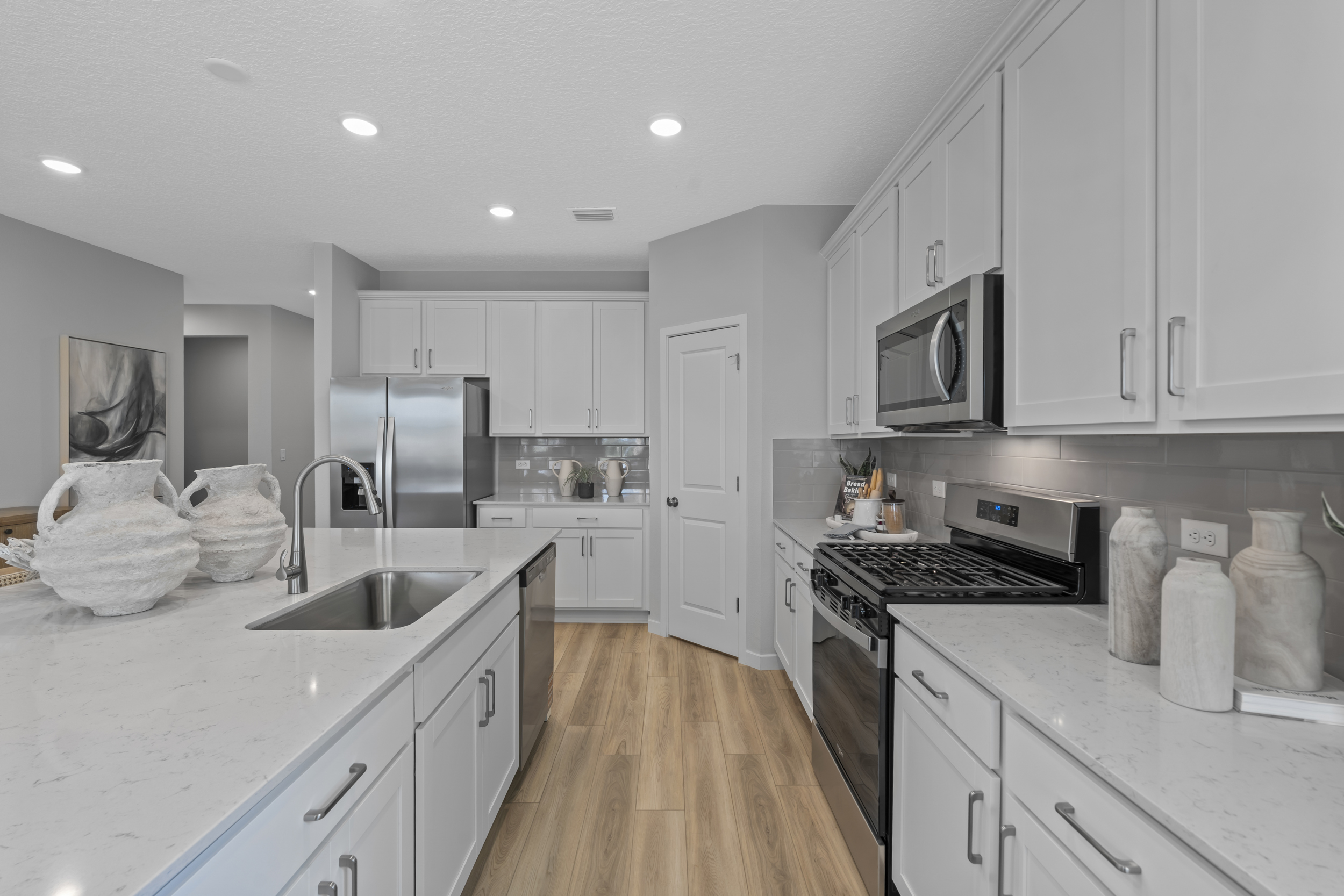 Coronado Model Home Kitchen with White Cabinets and Stainless Steel Appliances at Reserve East in Flagler Beach