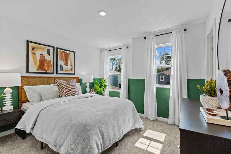 A bedroom with a bed and a lamp.