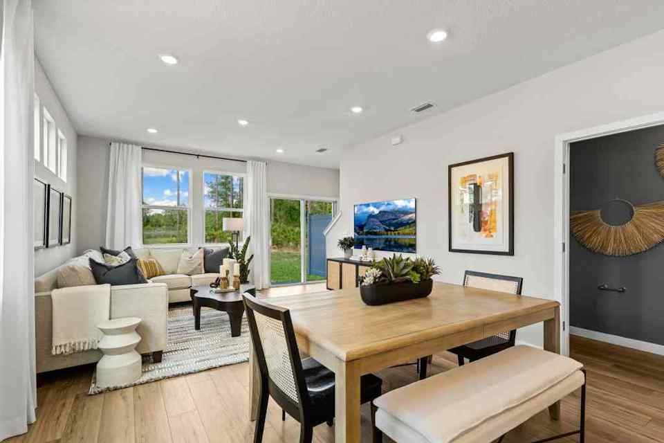 A living room with a large table and chairs.