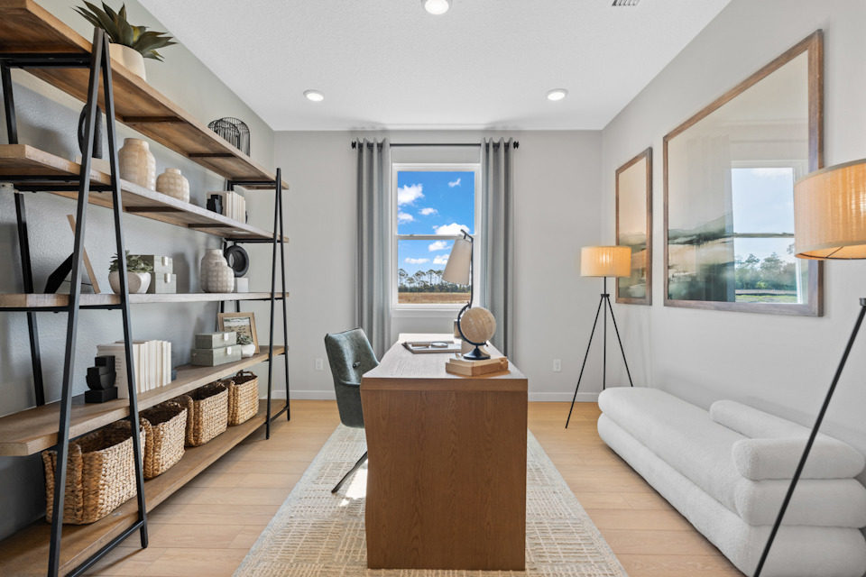 Kenai Model Home Study with Shelving, Desk and Chair, and small couch at Reserve East in Flagler Beach