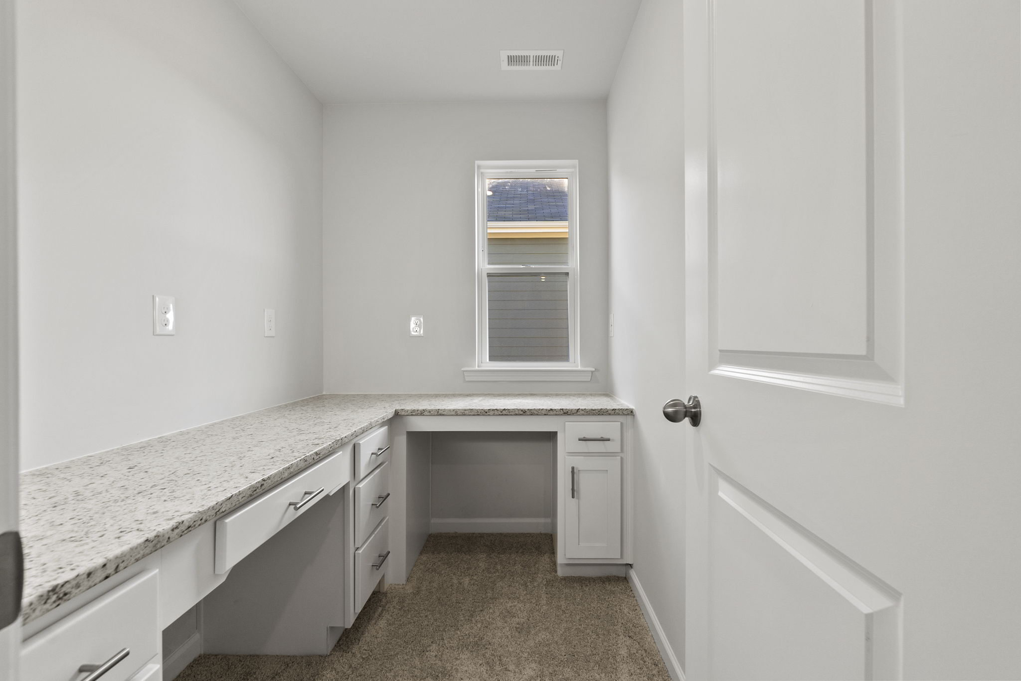 A kitchen with white cabinets.