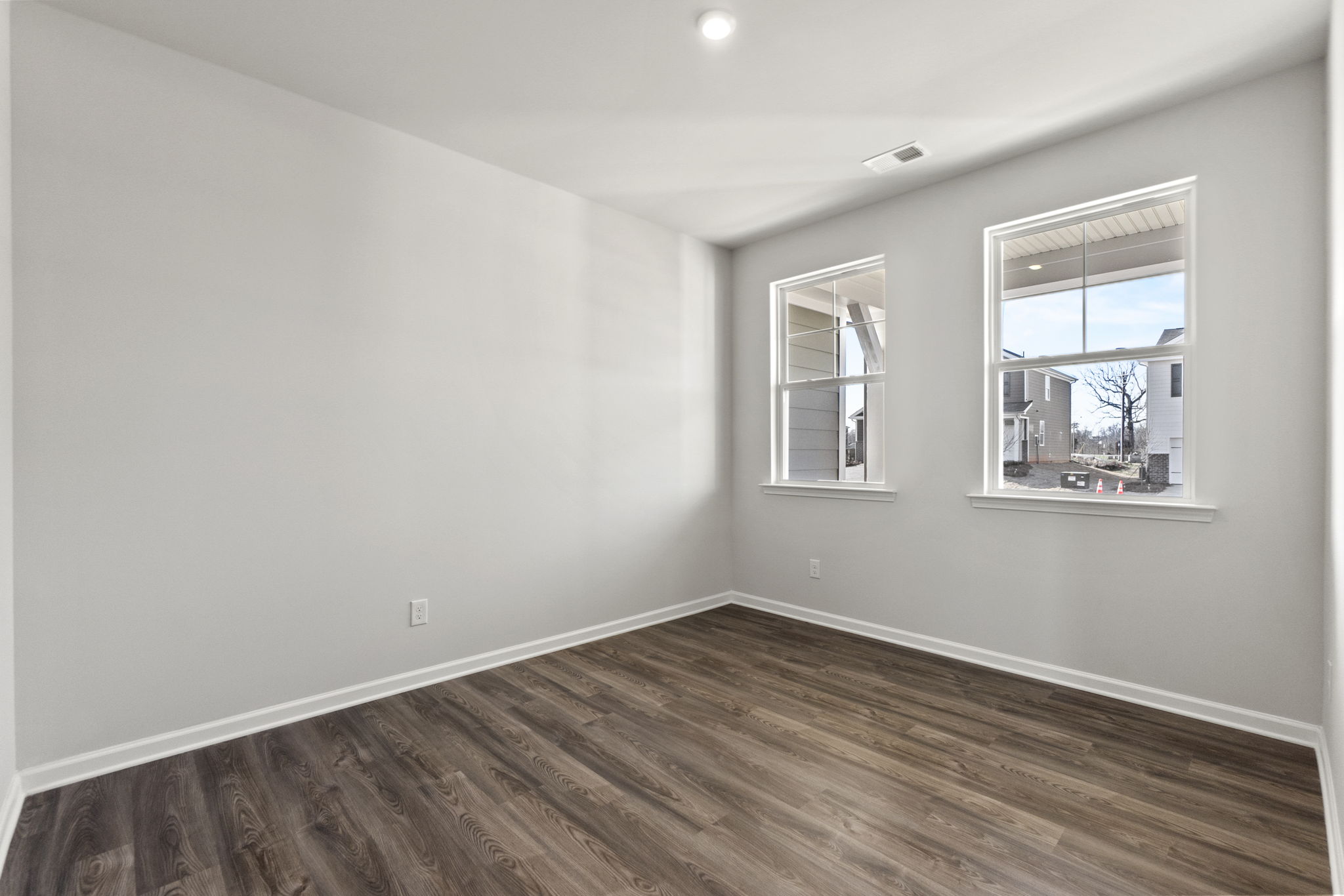 A room with a wood floor and windows.