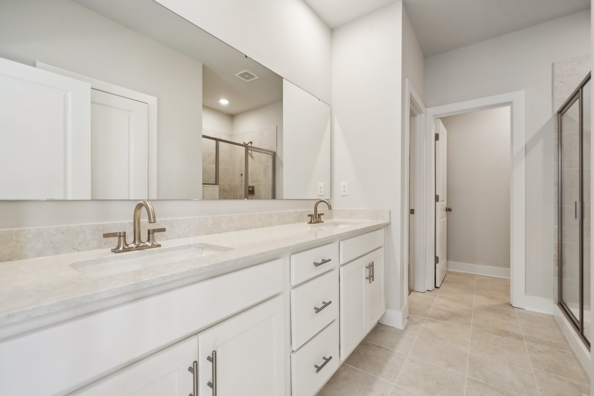 A bathroom with white cabinets.