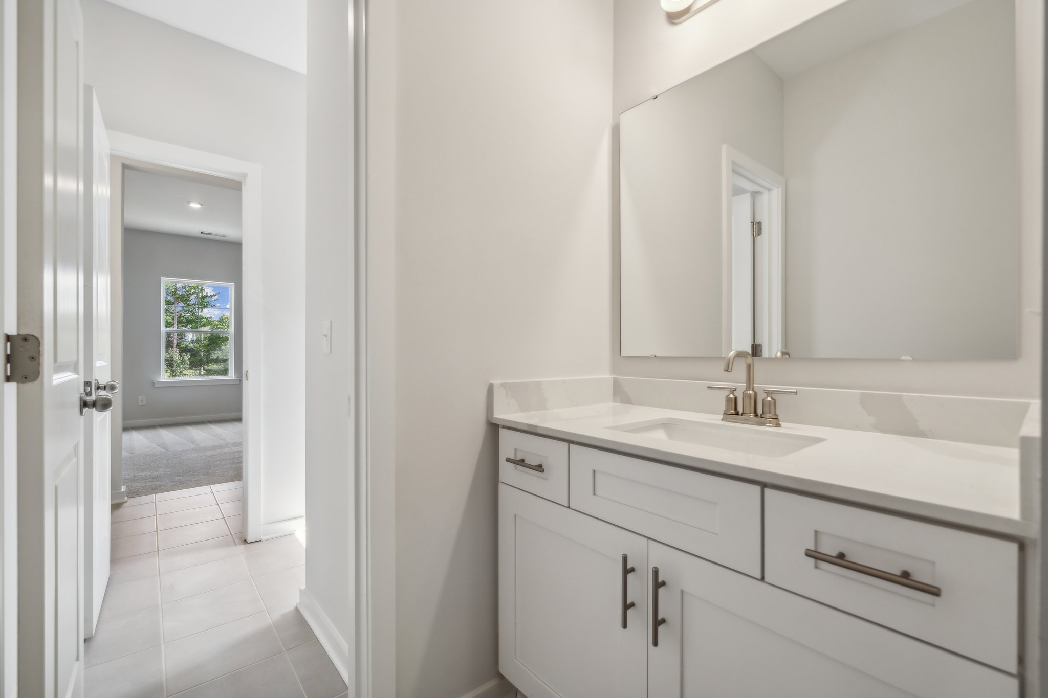 A bathroom with white cabinets.