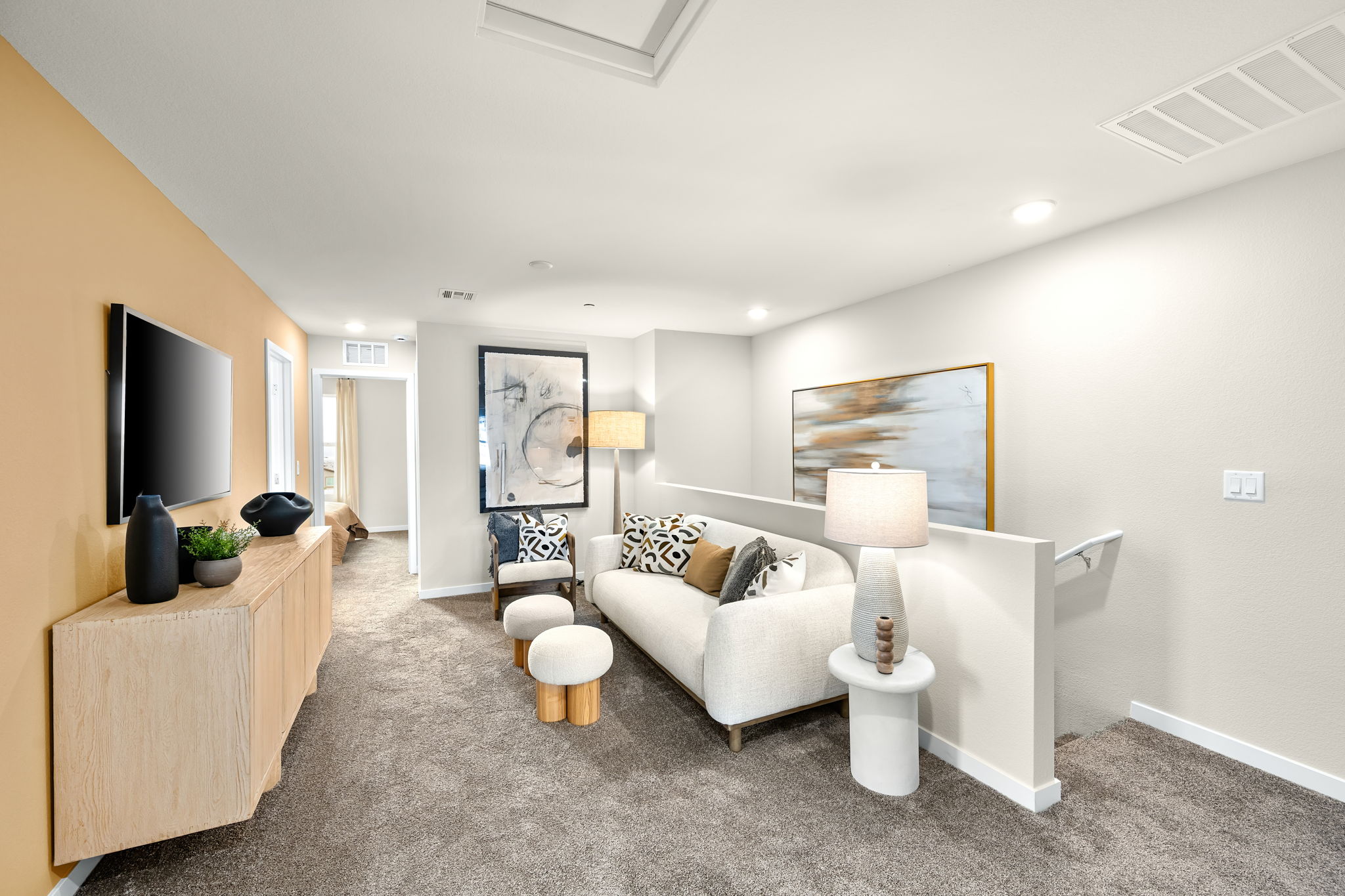 A living room with a white couch and a white chair.