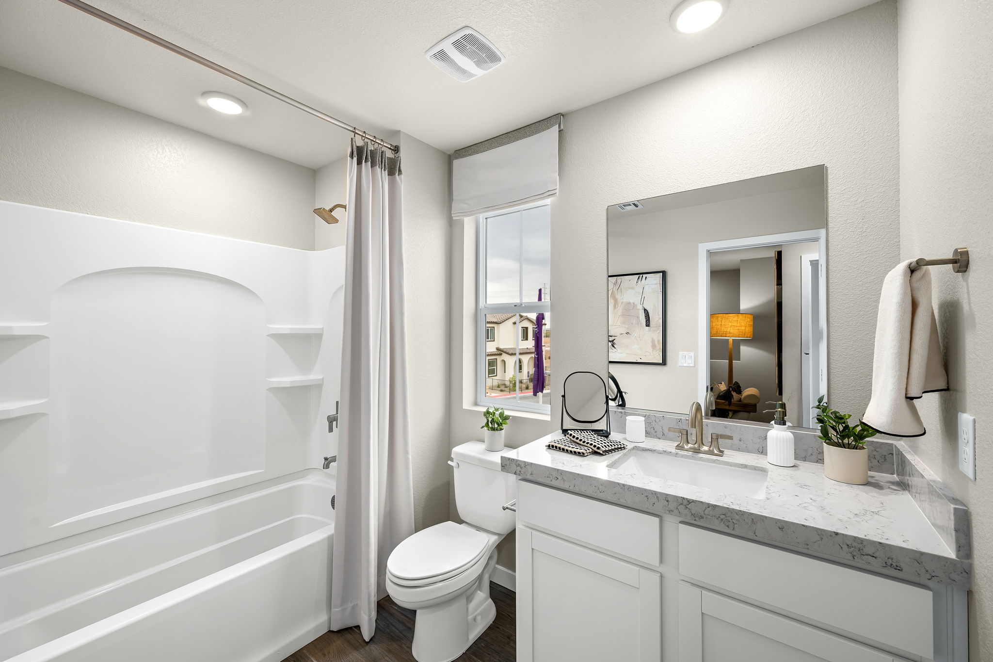 A bathroom with a tub sink and toilet.