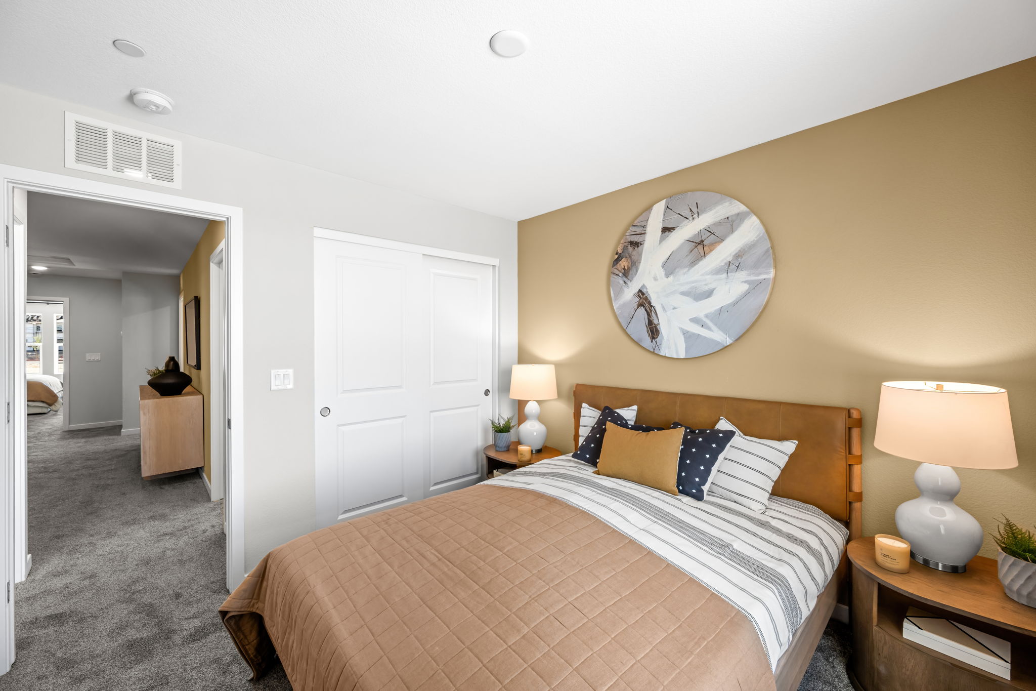 A bedroom with a large mirror.