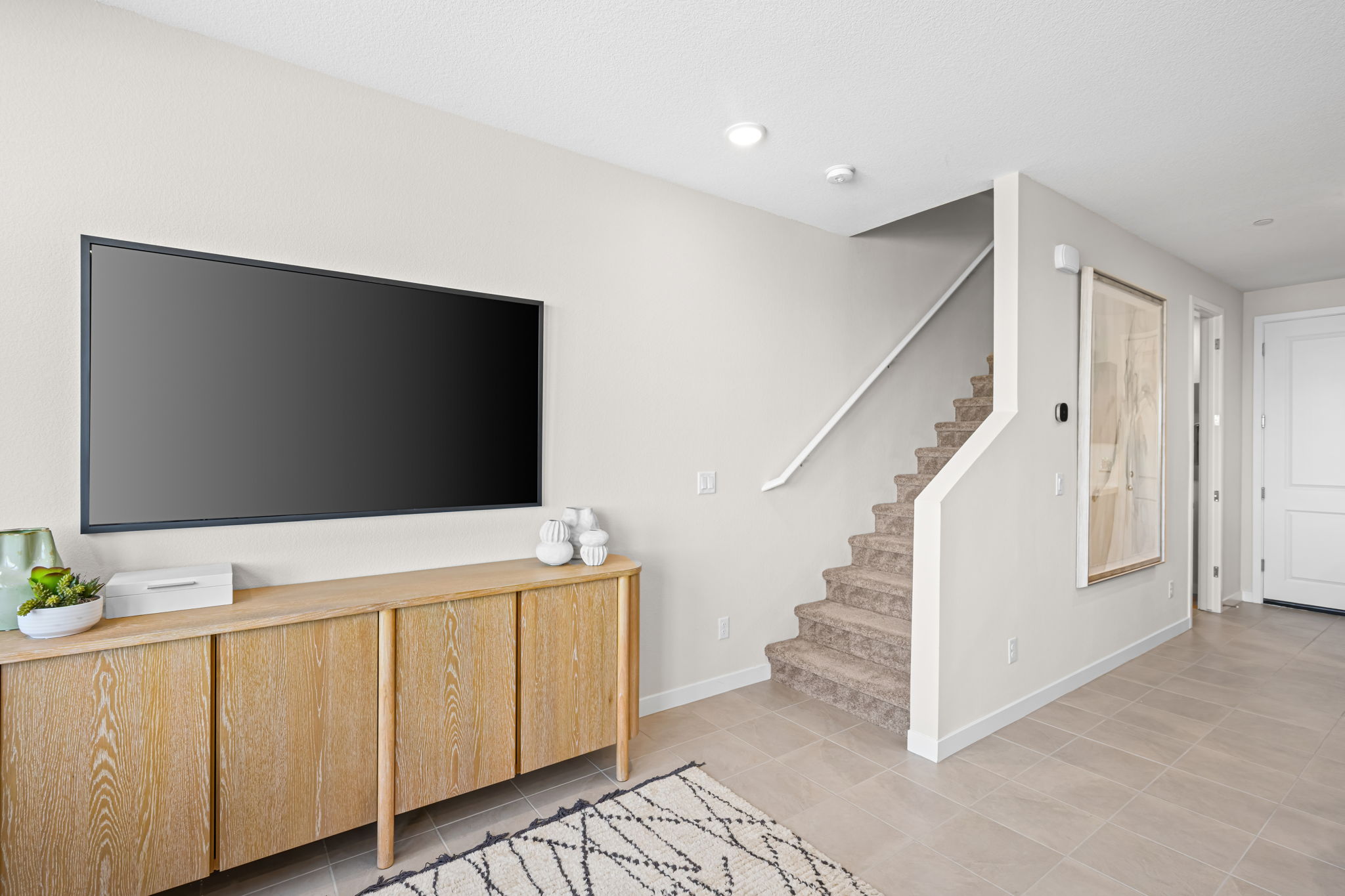 A room with a tv and stairs.