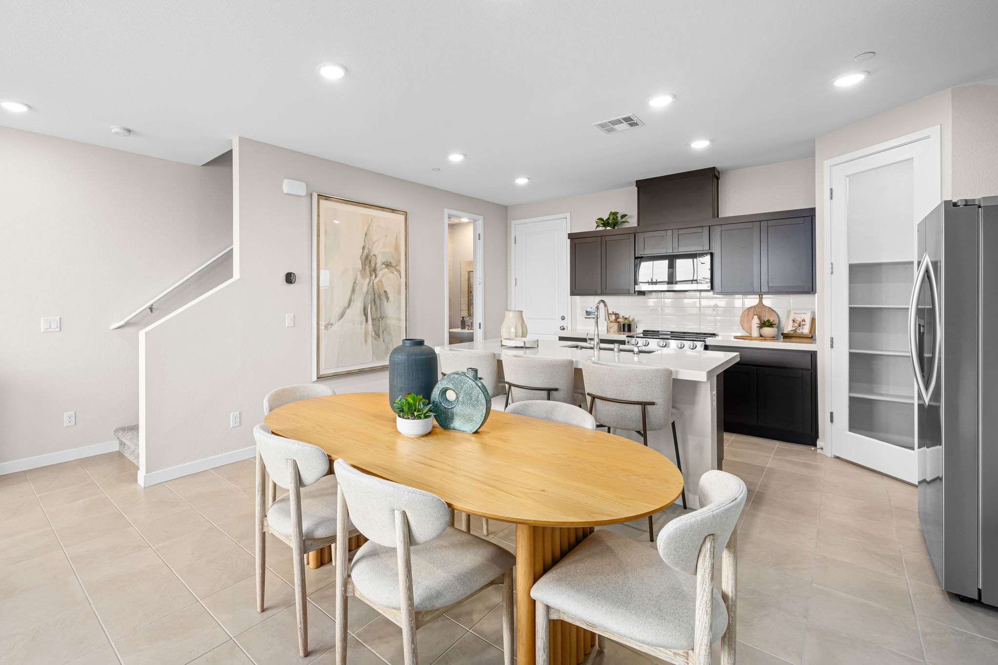 A kitchen with a dining table and chairs.