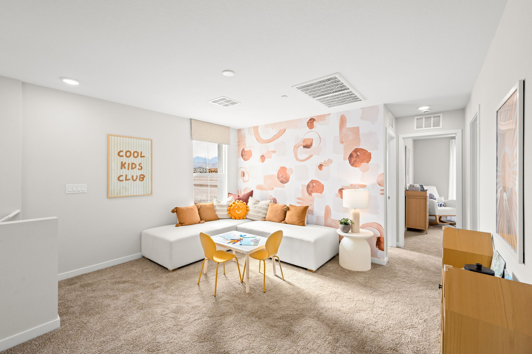 A living room with a large round table and chairs.