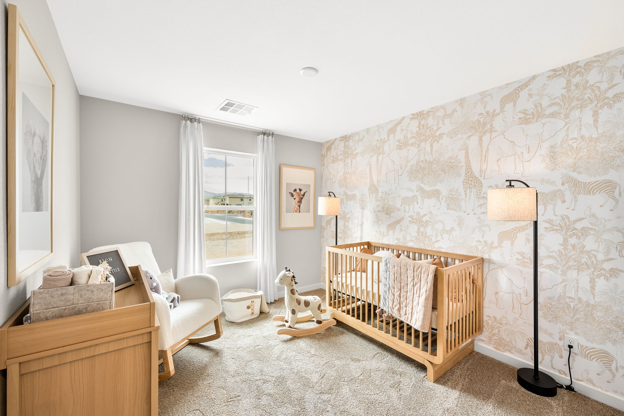 A room with a crib and a chair.