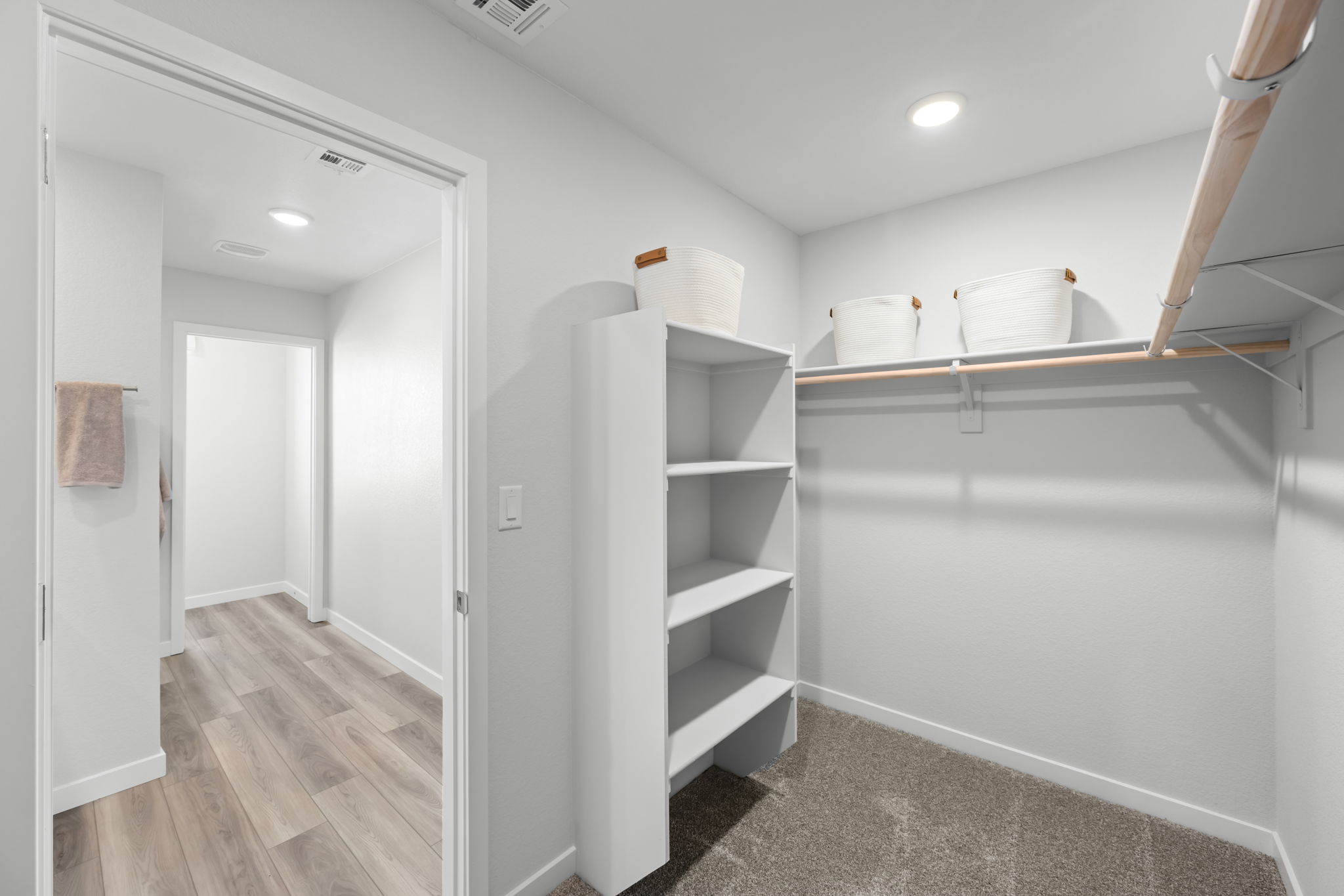 A white room with a white shelf and white walls.