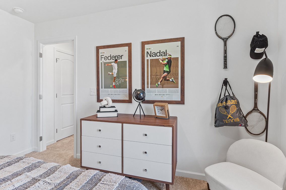 A room with a white chair and a white door with a picture on it.