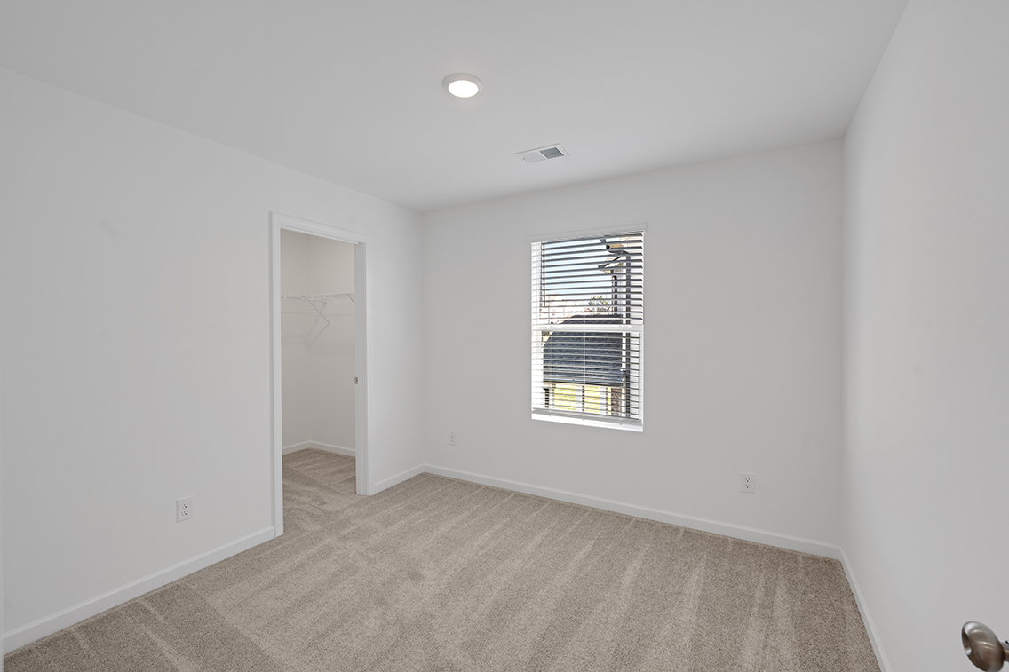 A room with a window and a carpet.