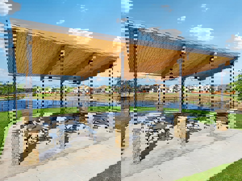 A covered area with benches and a body of water in the background.