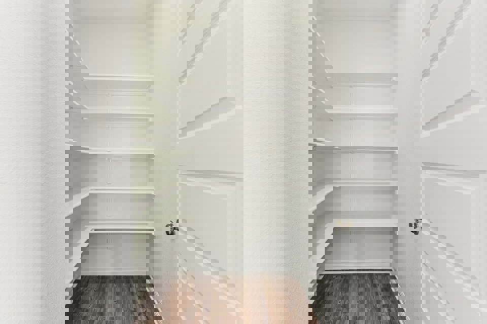 A white closet with a door.