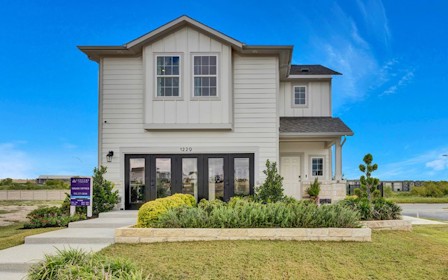 A white house with a sign in front of it.