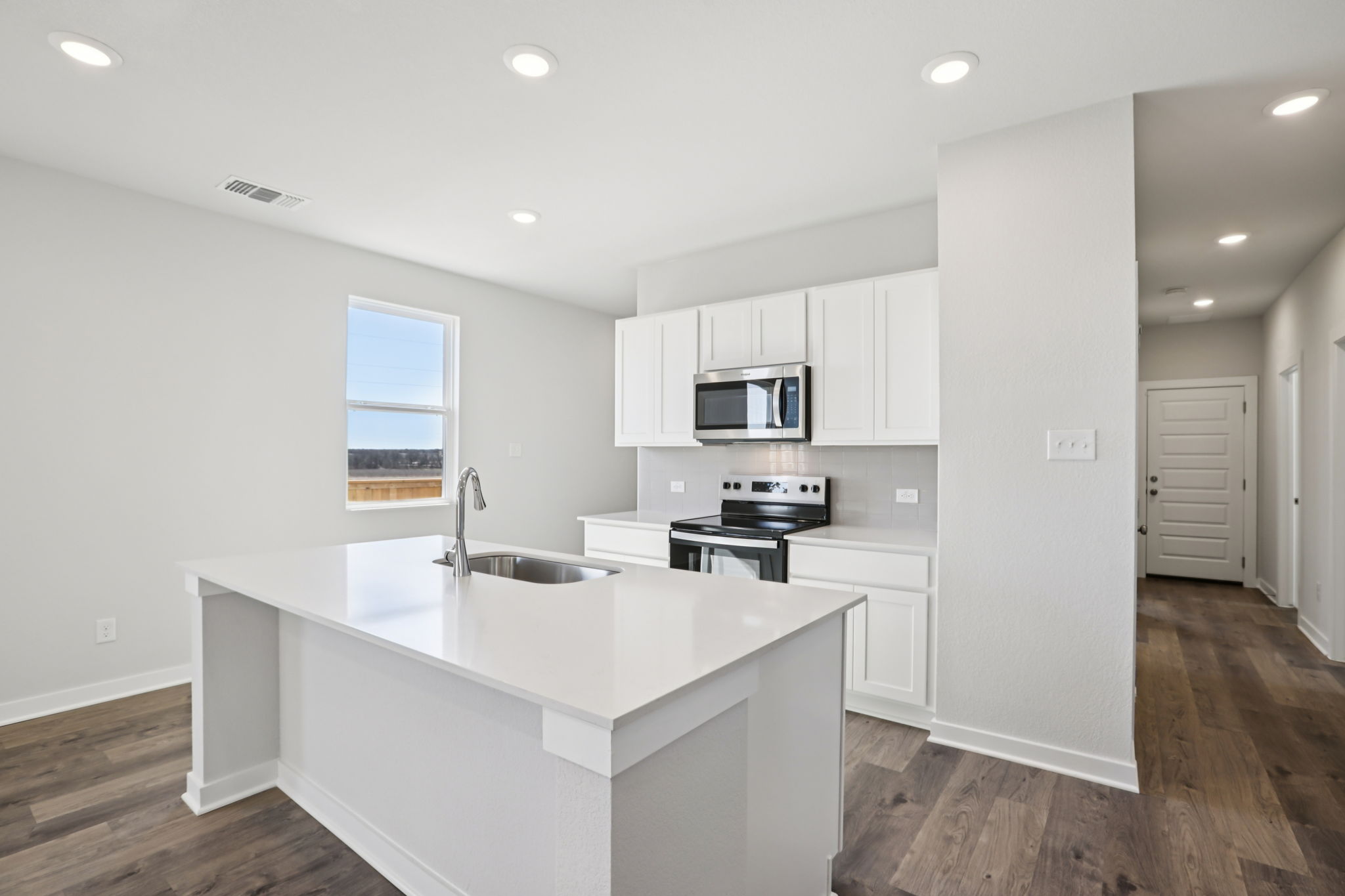 A kitchen with white cabinets.