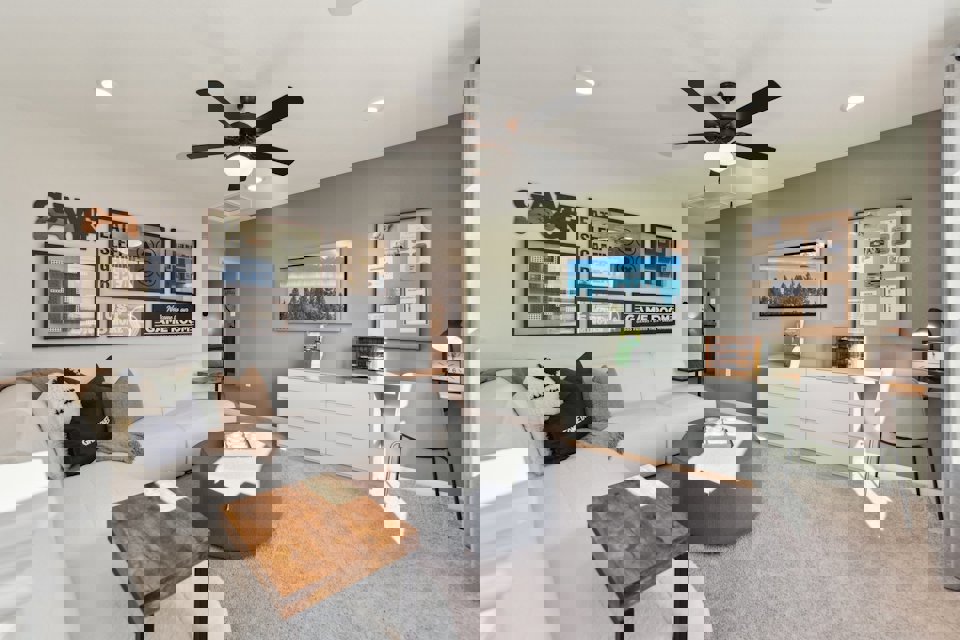 A living room with a couch and a fan.