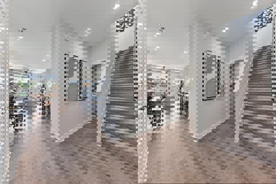 A room with a wood floor and a wood staircase.