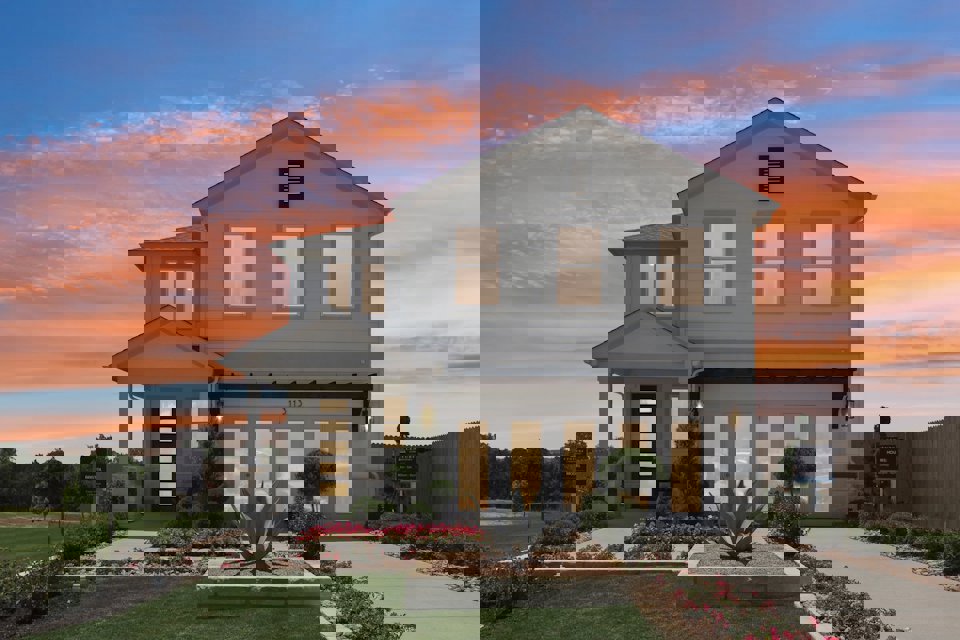 A house with a fountain in front of it.