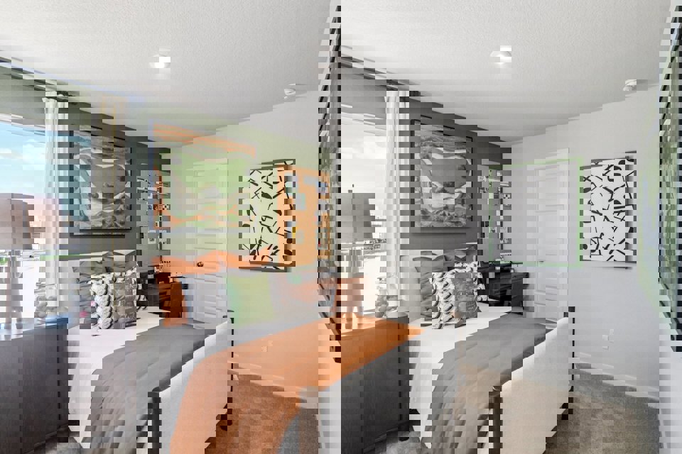 A bedroom with a bed and a chair.