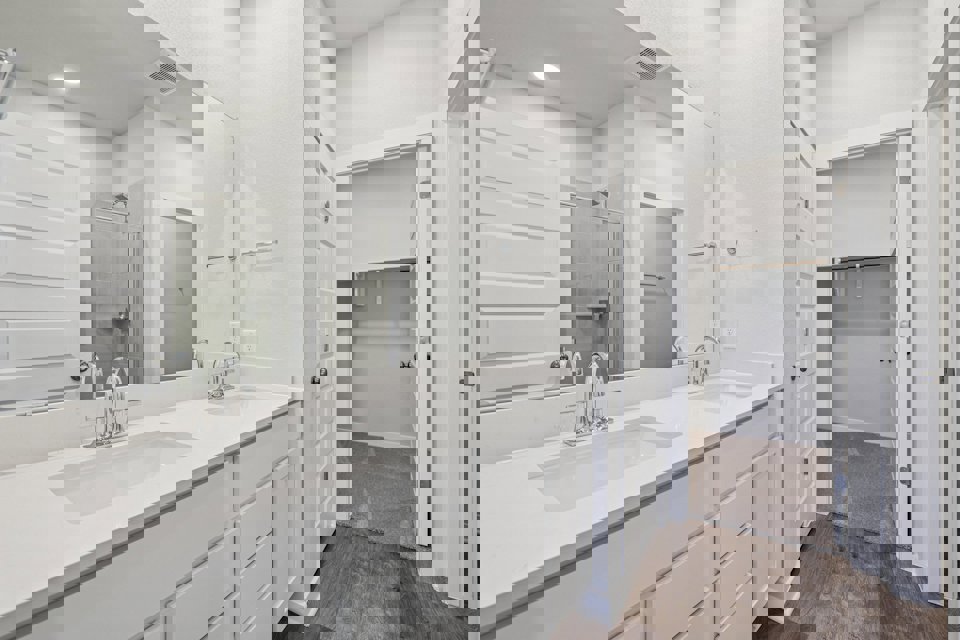 A bathroom with white cabinets.