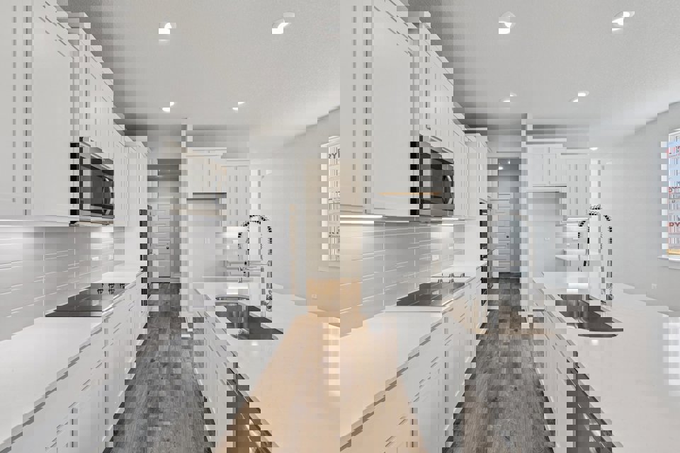 A kitchen with white cabinets.