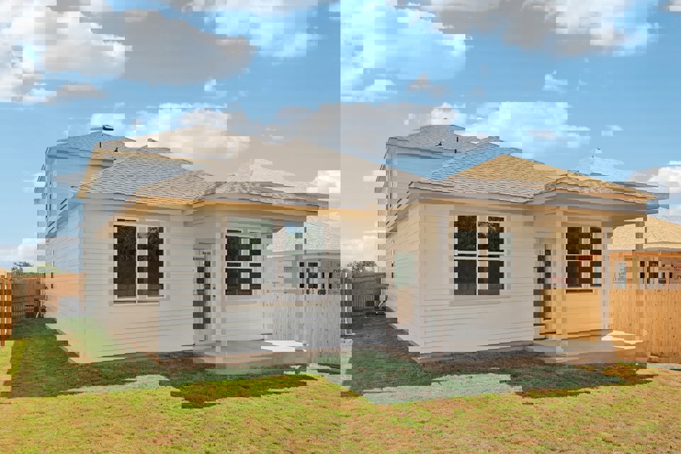 A house with a fence and grass.