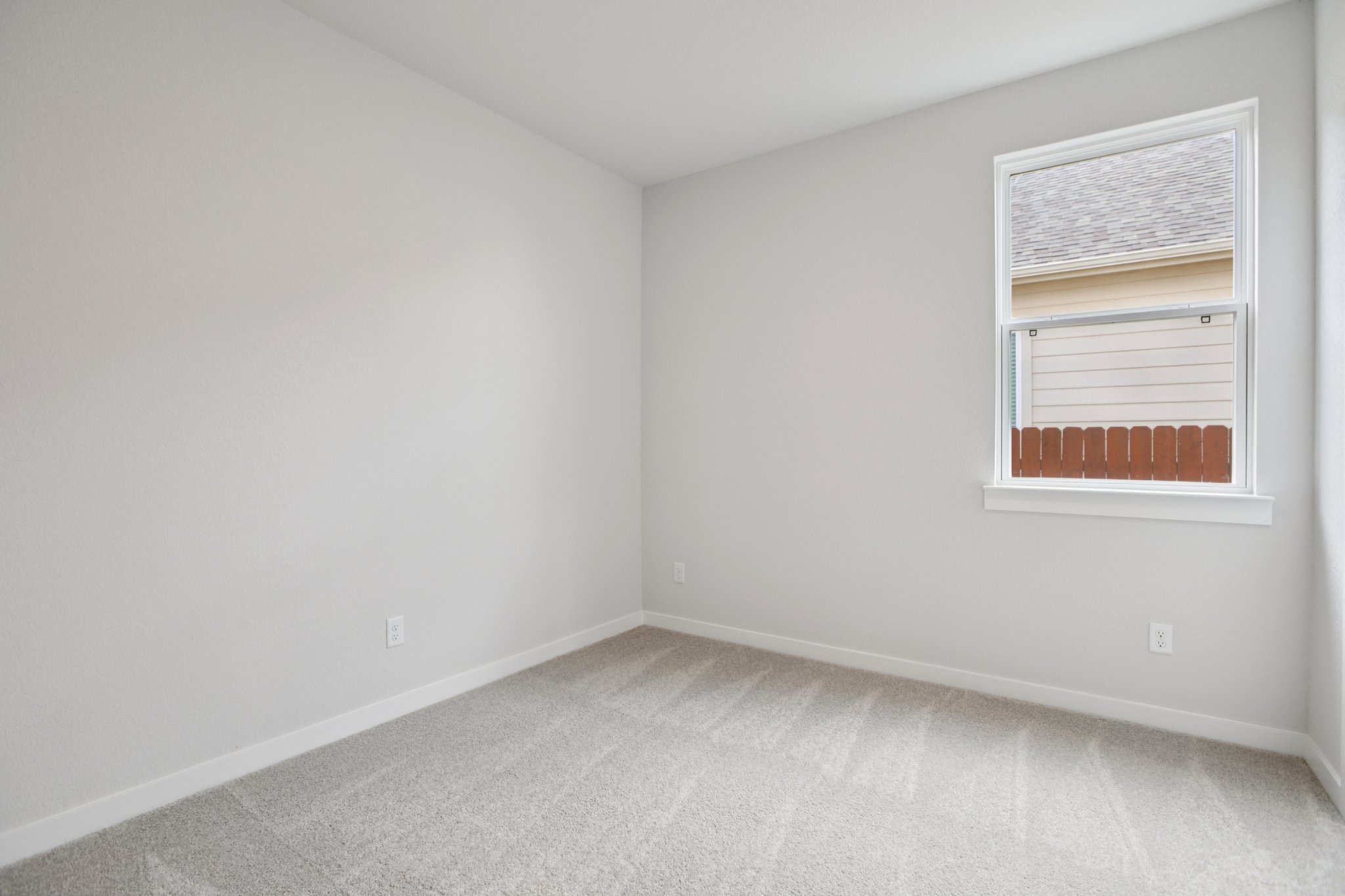 A room with a window and a rug.