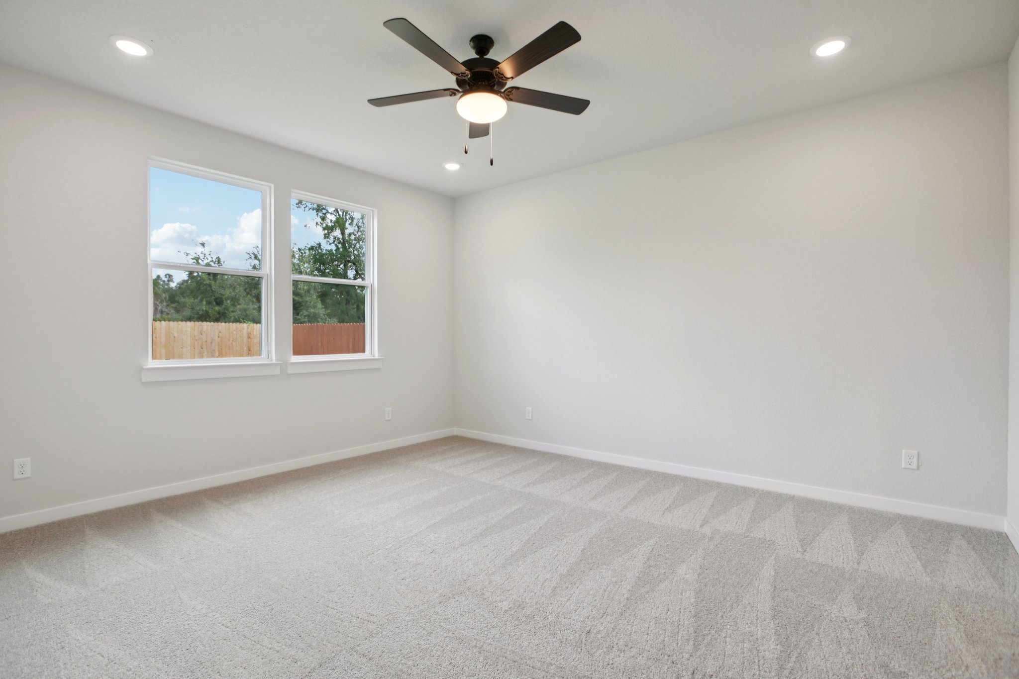 A room with a ceiling fan and a window.