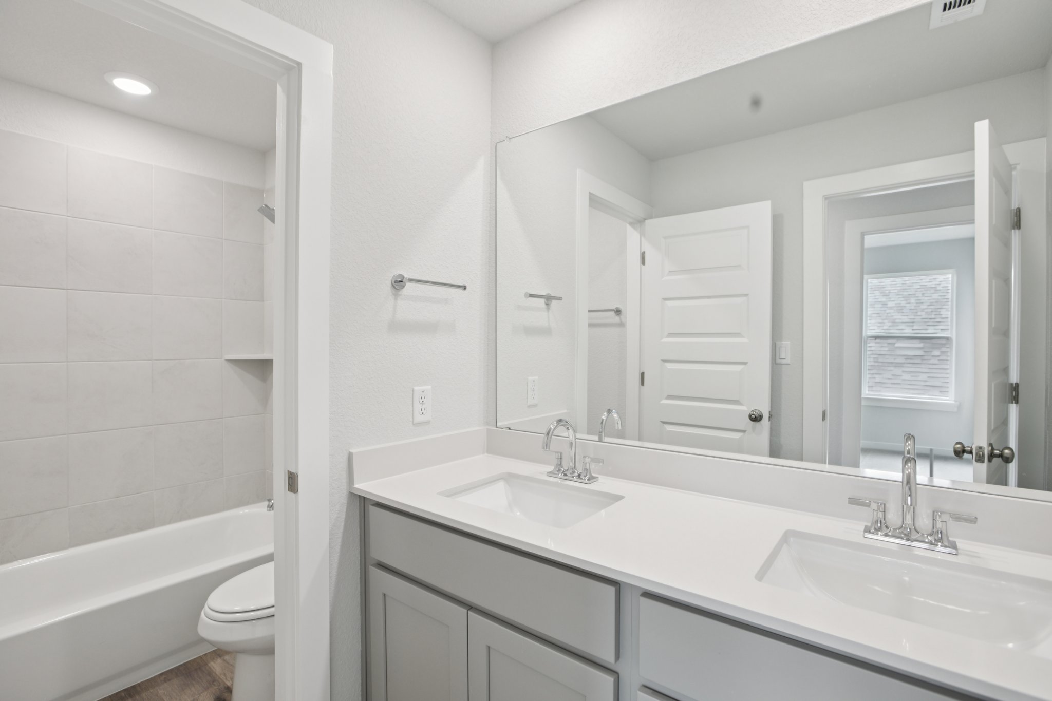 A bathroom with a large mirror.