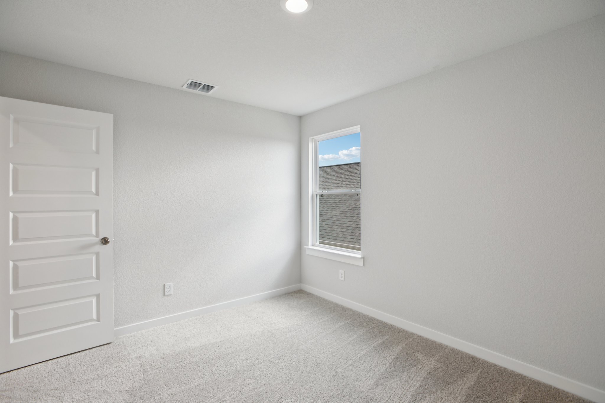 A room with white walls and a window.