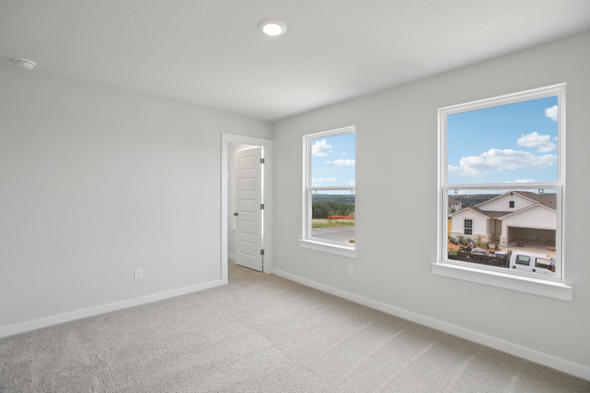 A room with a window and a painting on the wall.