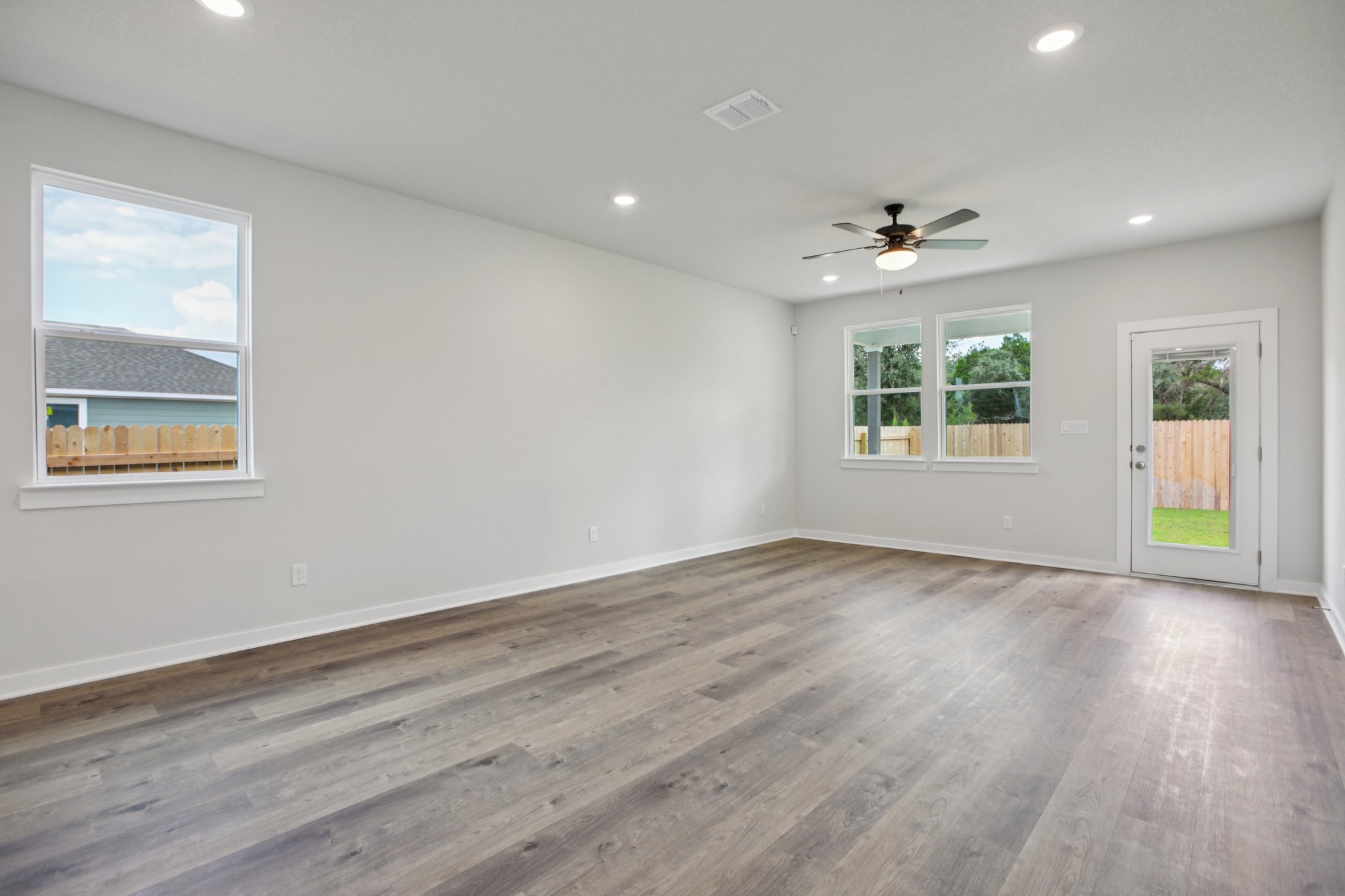 A room with a wood floor and a ceiling fan.