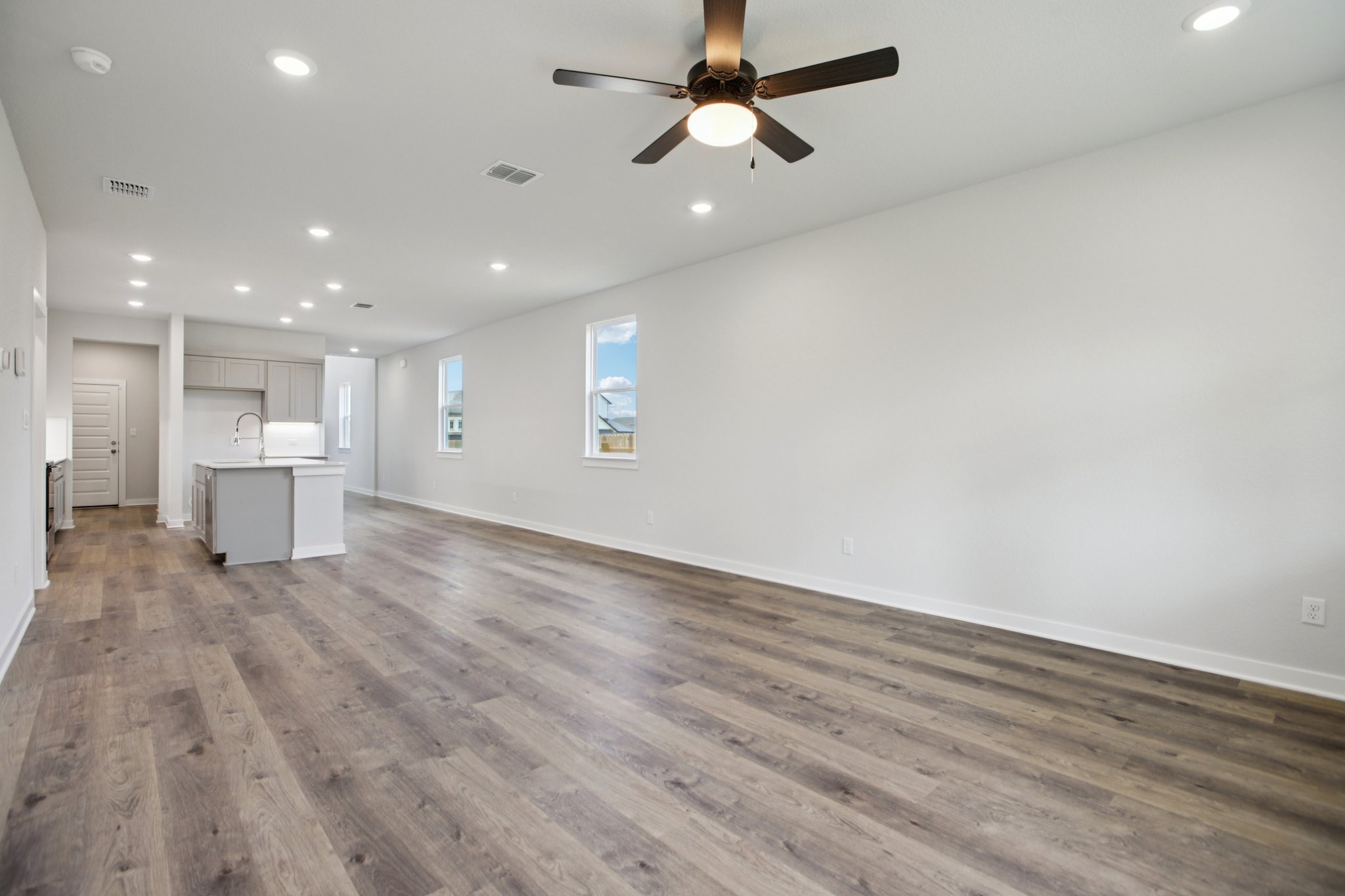 A room with a wood floor and a ceiling fan.