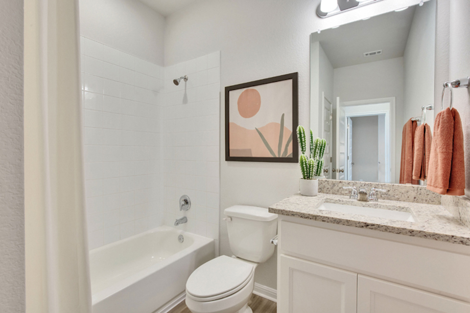 A bathroom with a sink toilet and bathtub.