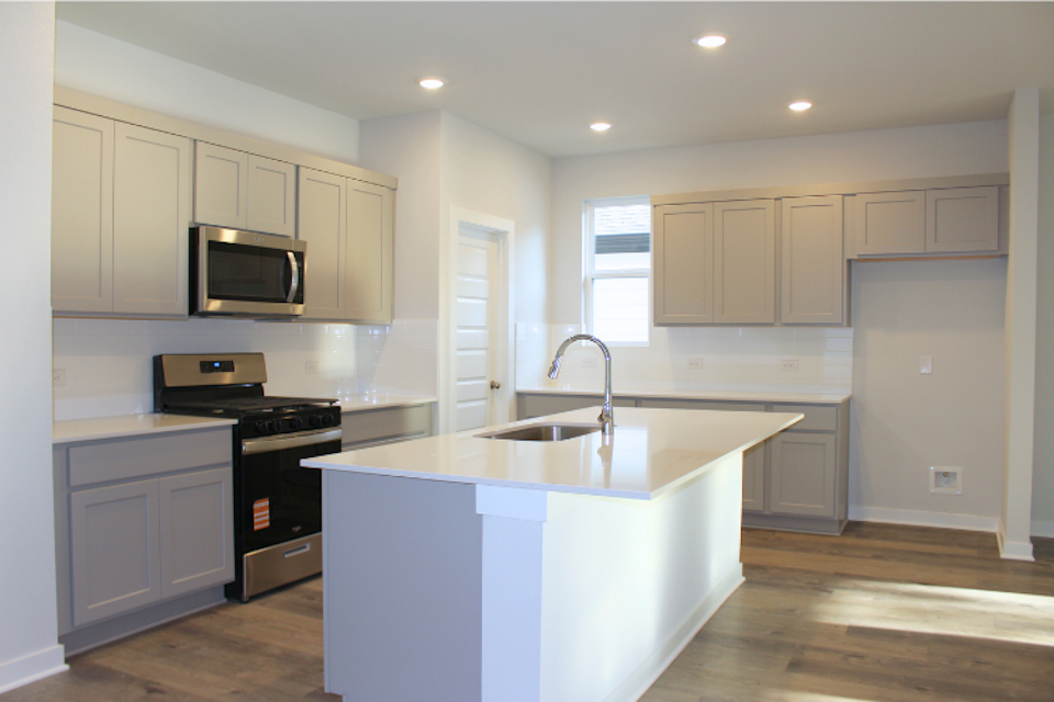 A kitchen with white cabinets.