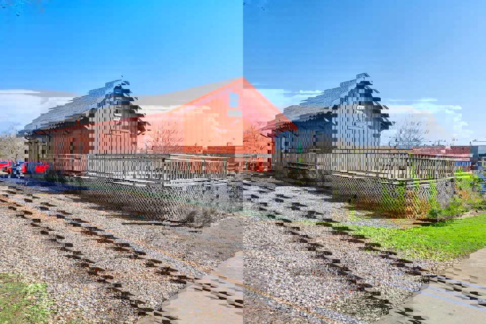 A train station with a red barn.