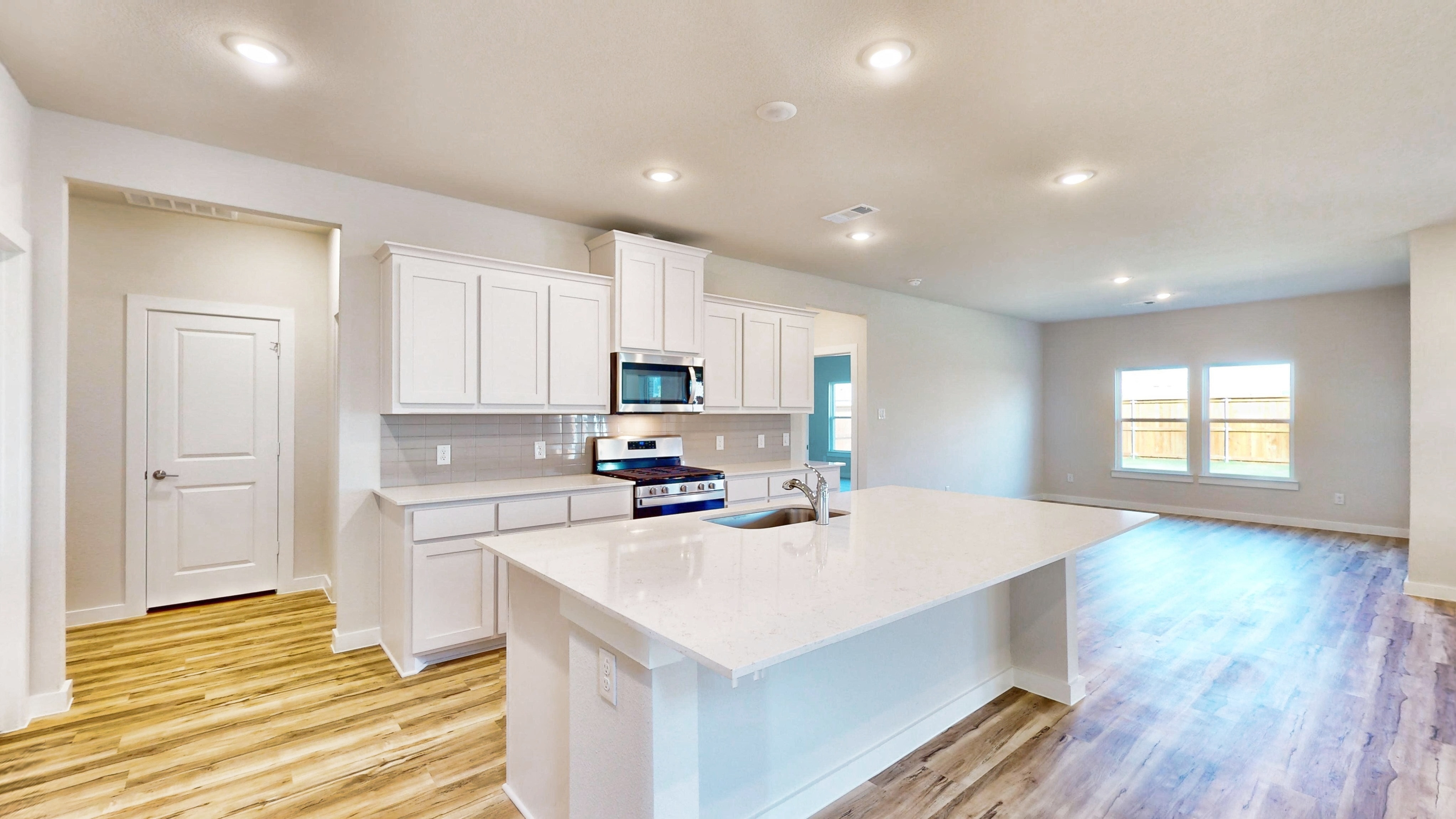 A kitchen with white cabinets.