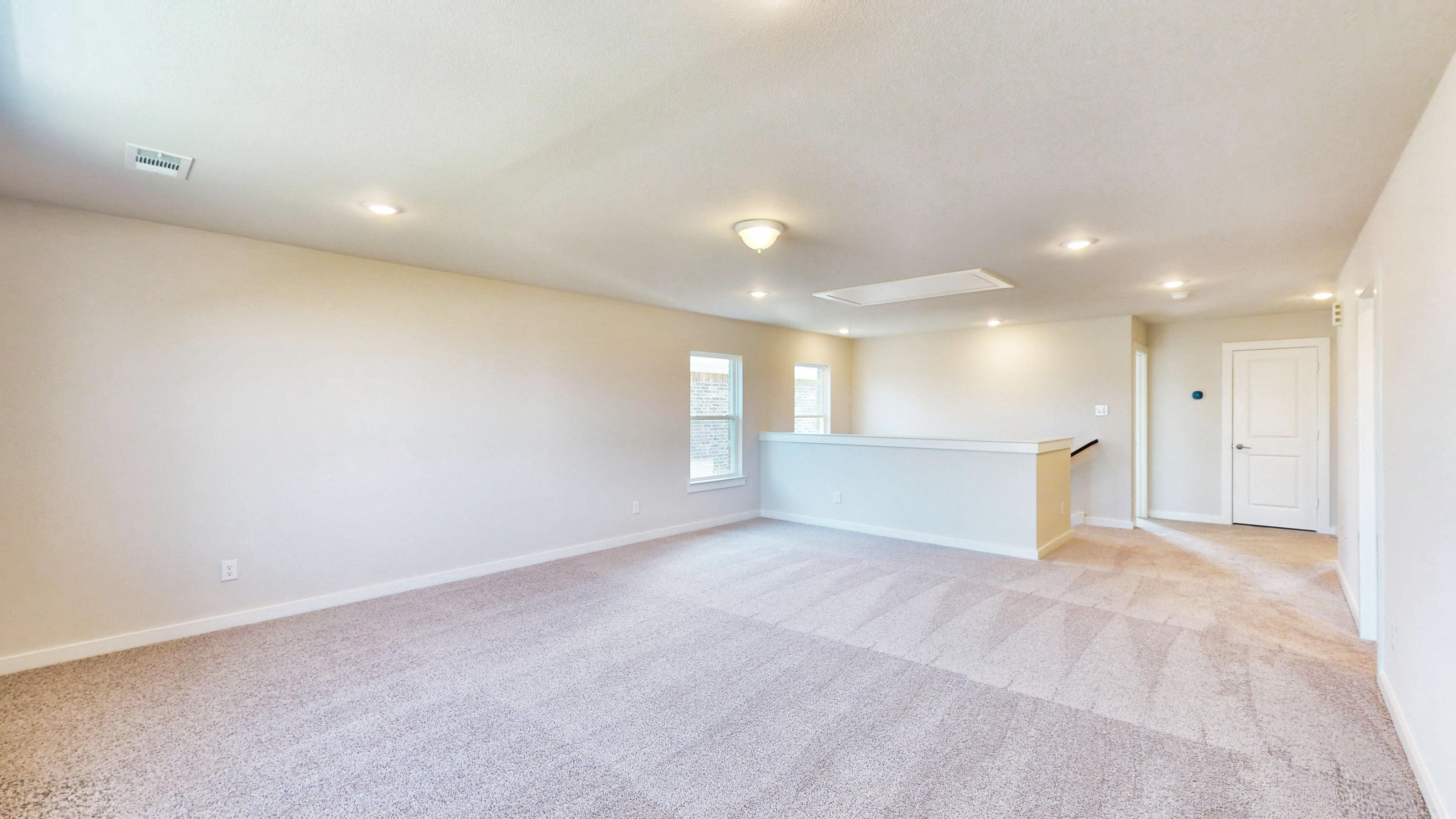 A room with a carpet and a white door.