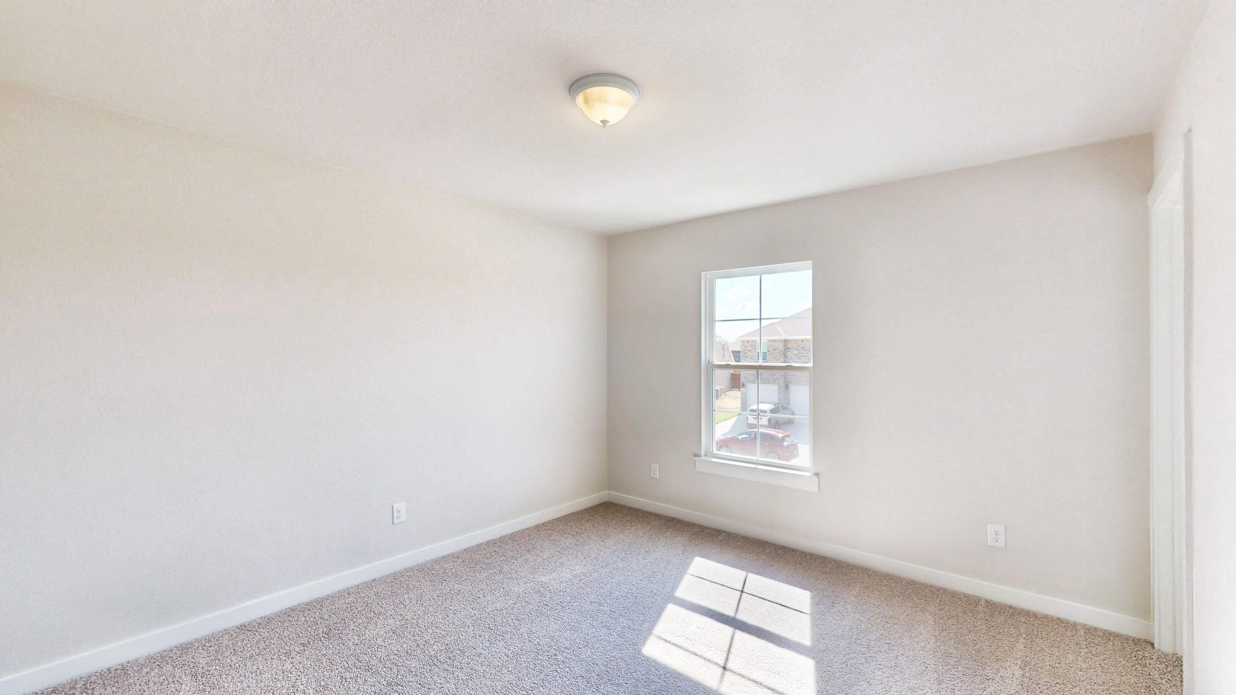 A room with a window and a rug.